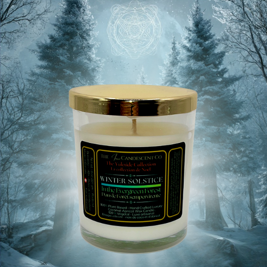 Candle with a gold lid and label in front of a snowy forest background