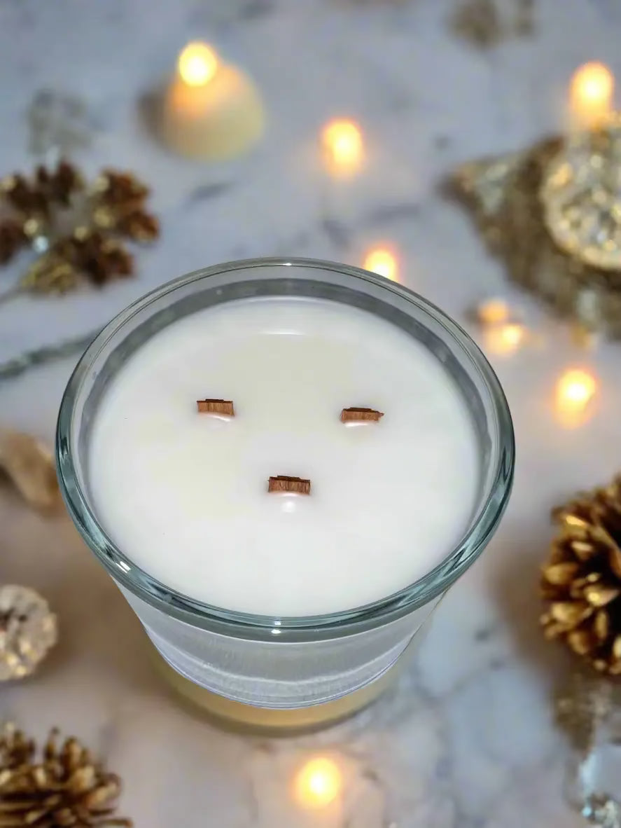 Candle with facial features made from wooden sticks on a gray surface