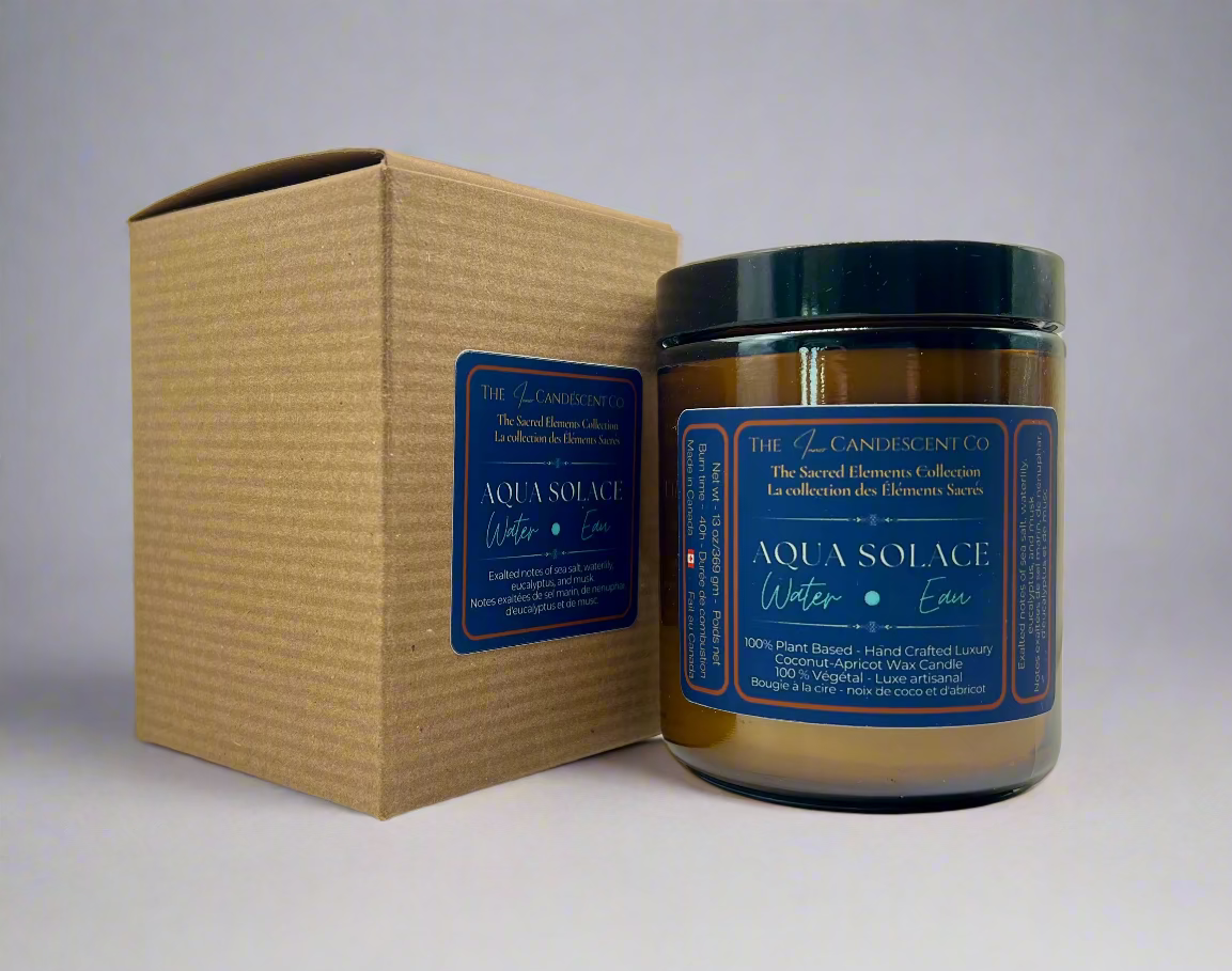 Candle with blue label and cardboard box on a light background