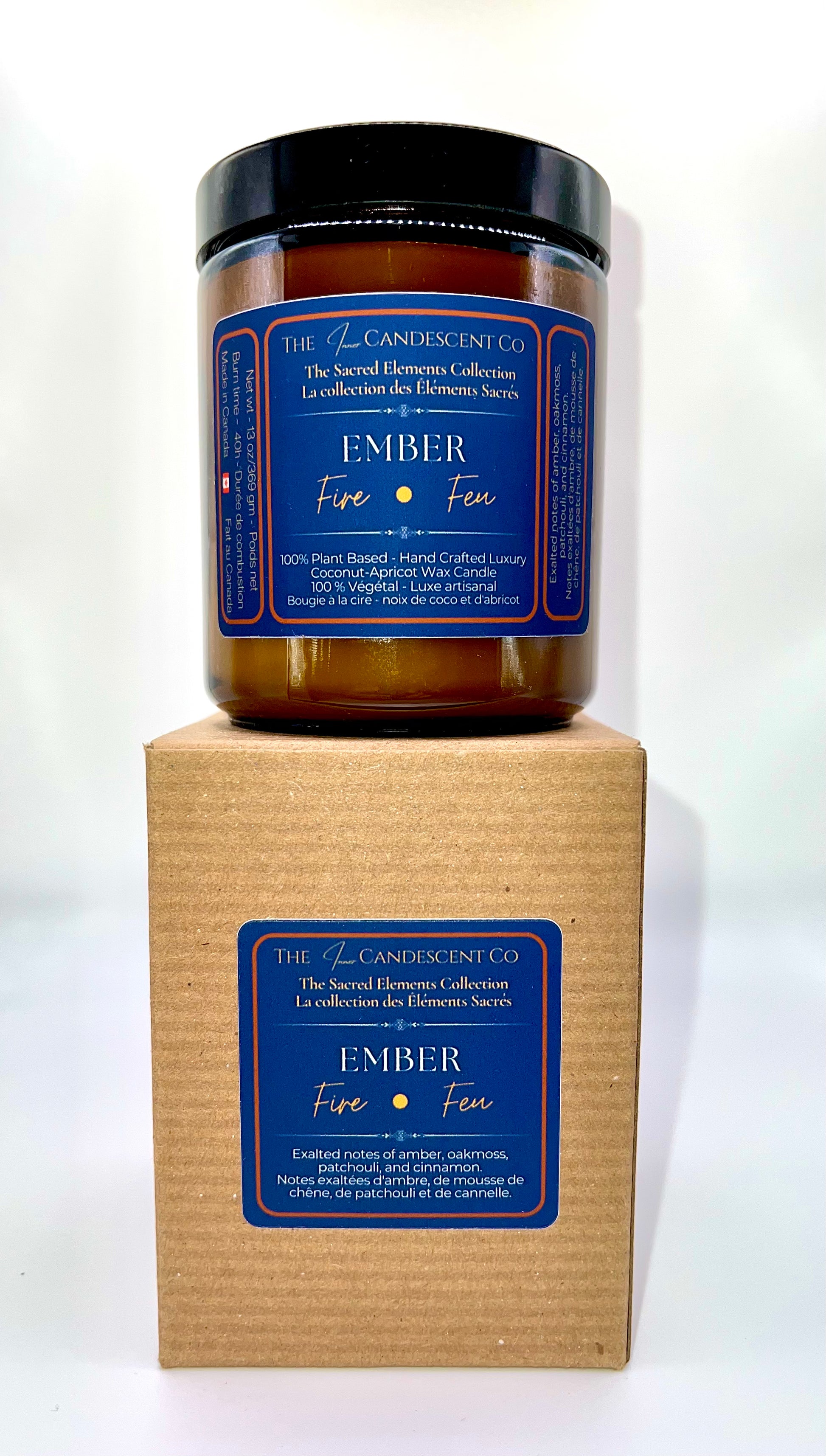 Candle with blue label on a cardboard box against a white background