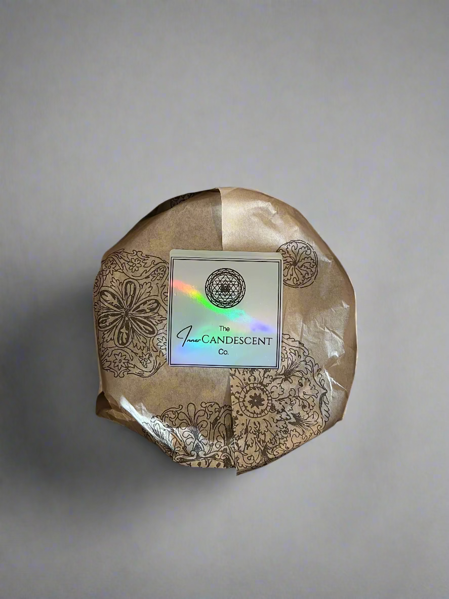 Round product with decorative packaging in a cardboard box, featuring a visible brand label.