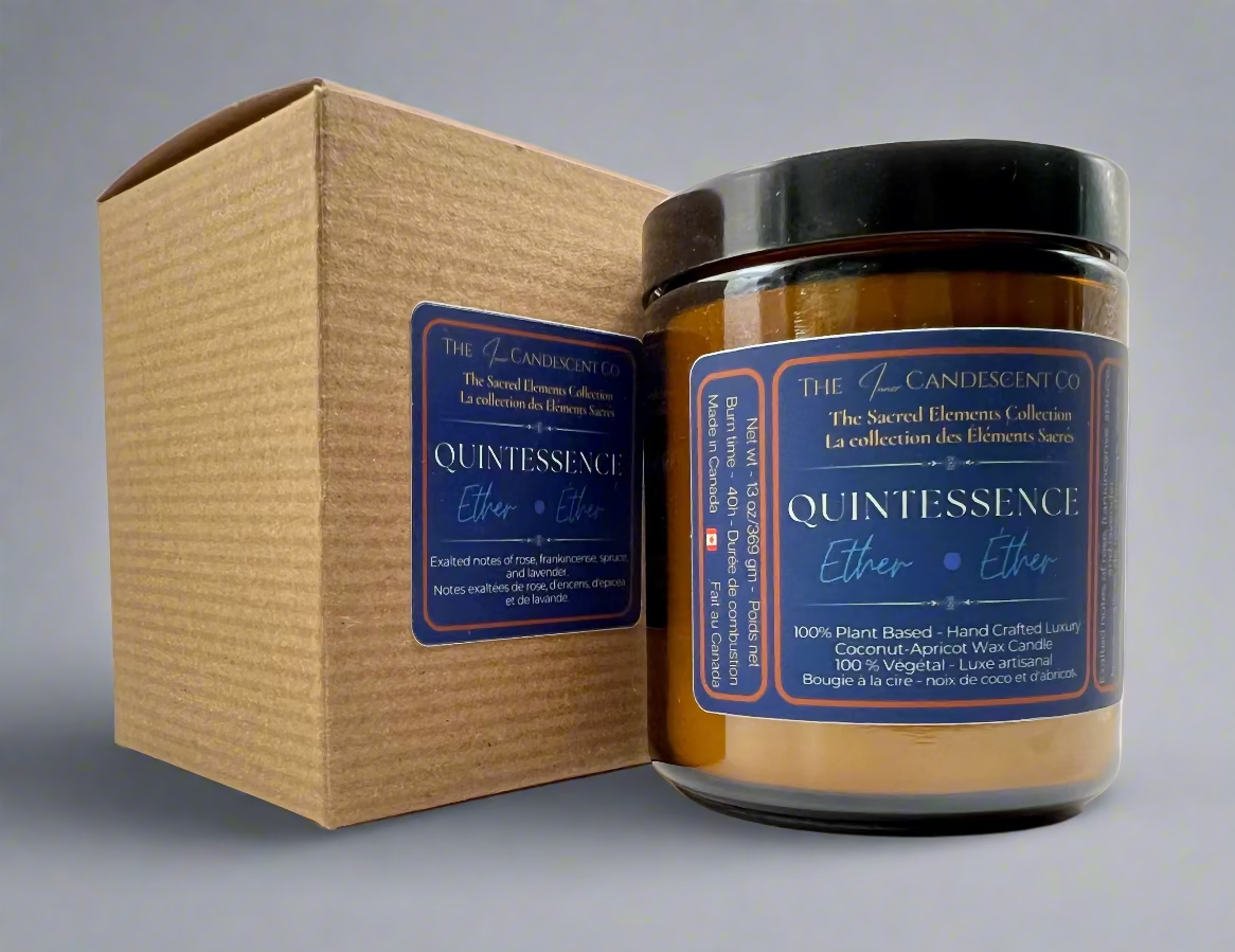Candle jar labeled 'Quintessence' with a matching box on a gray background