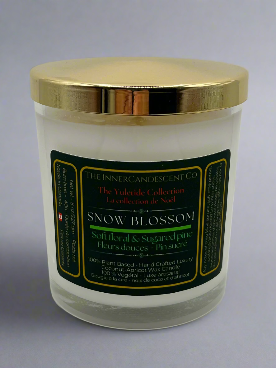 Candle with gold lid and green label on a white background