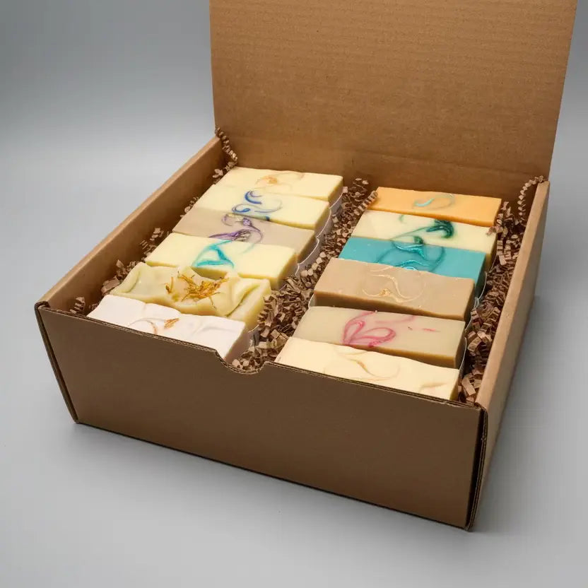 Box of assorted soaps with decorative elements on a light blue surface