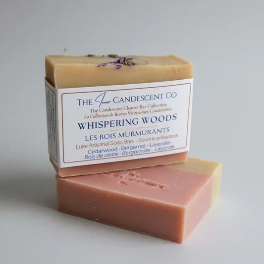 Bar of soap with 'Whispering Woods' label on a textured surface