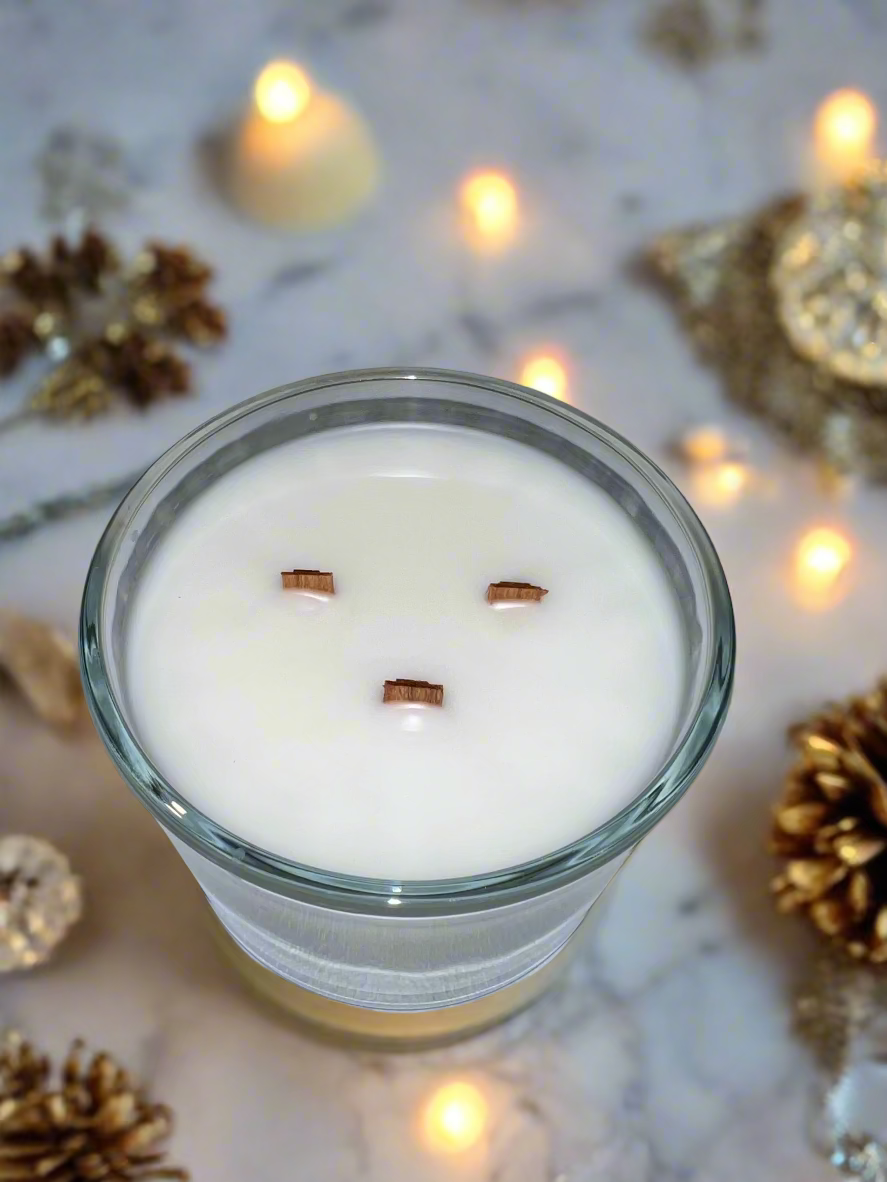 Candle with facial features made from wooden sticks on a gray surface